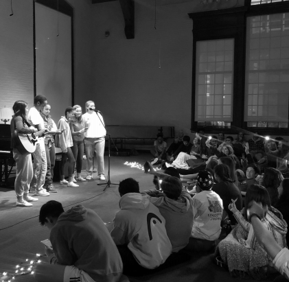 Students performing at the first Open Mic of this academic year, the audience showing
their support by waving phone flashlights in time to the song.