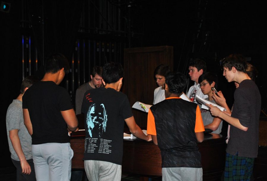 Cast members gathered around the piano to practice songs for the winter musical, Legally Blonde.