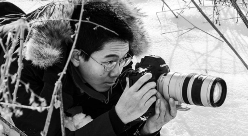 Teddy Deng '20 crouching in the snow to get the perfect shot.